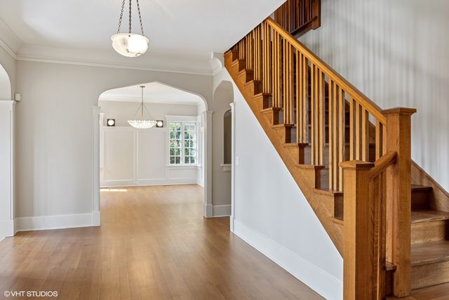 a view of a hallway with wooden floor and staircase