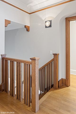 a spacious bedroom with a bed a chandelier and window