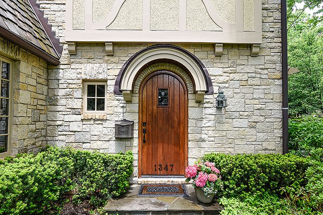 a front view of a house with a yard and potted plants