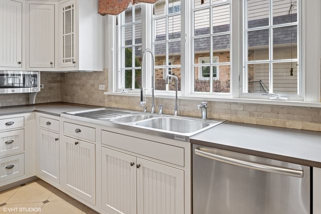a stove top oven sitting inside of a kitchen and white cabinets