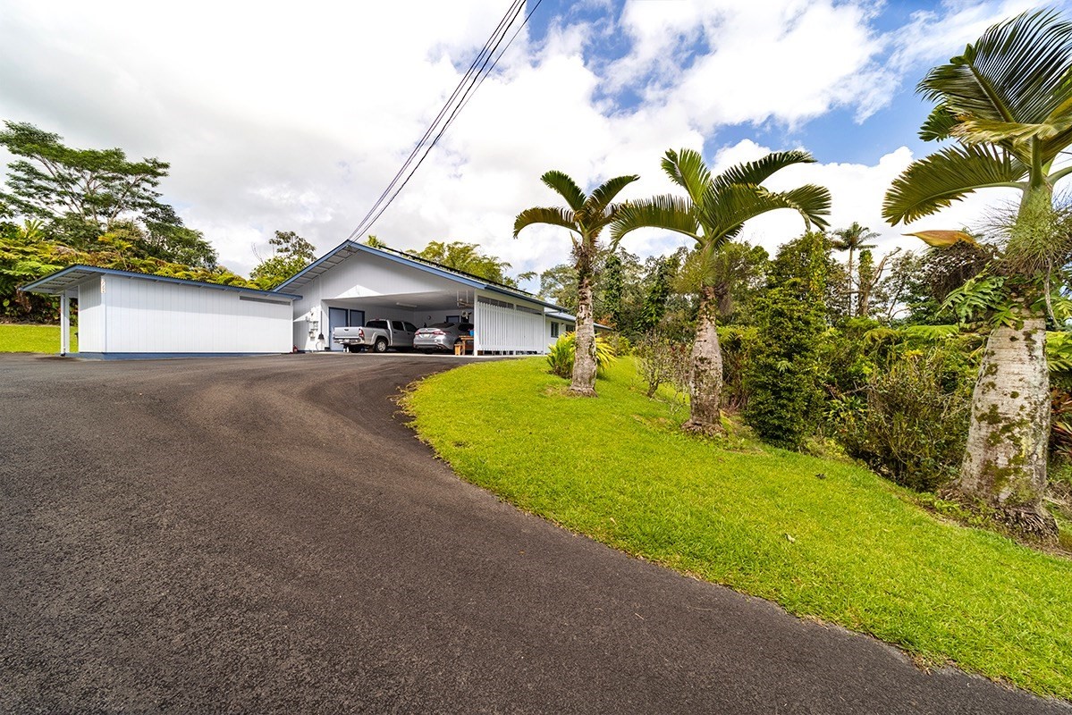 17-294 Volcano Road Kurtistown, HI 96749 - Photo 27 of 30 a view of a patio with table and chairs under an umbrella