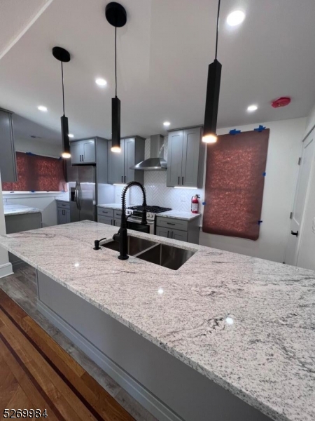 a kitchen with stainless steel appliances granite countertop sink a refrigerator and chairs