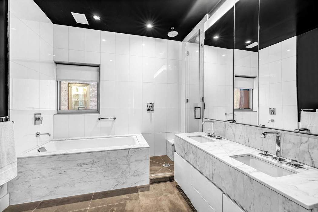 471 Washington Street, Unit 4B Manhattan, NY 10013 - Photo 8 of 11 a spacious bathroom with a double vanity sink mirror and bathtub