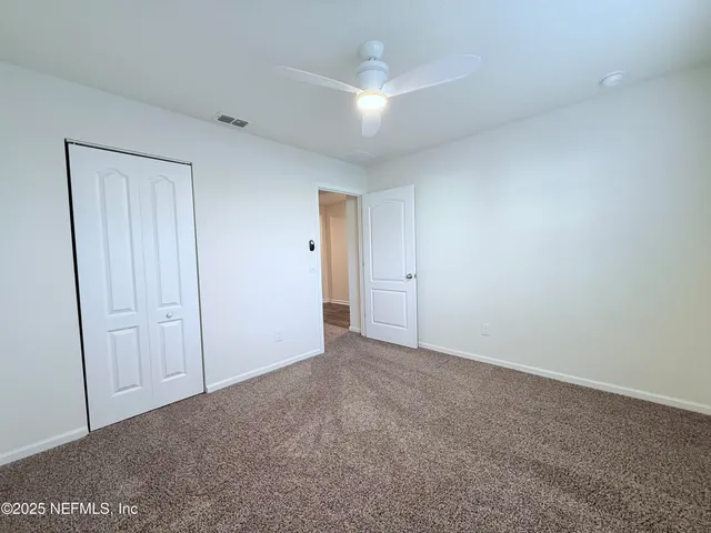 a view of an empty room and closet area