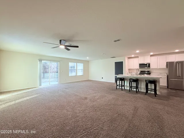 a view of a livingroom with furniture and a ceiling fan