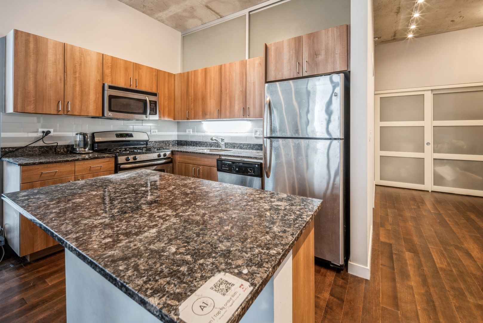235 West Van Buren Street, Unit 4214 Chicago, IL 60607 - Photo 3 of 16 a kitchen with stainless steel appliances granite countertop a refrigerator oven a sink dishwasher and wooden cabinets with wooden floor