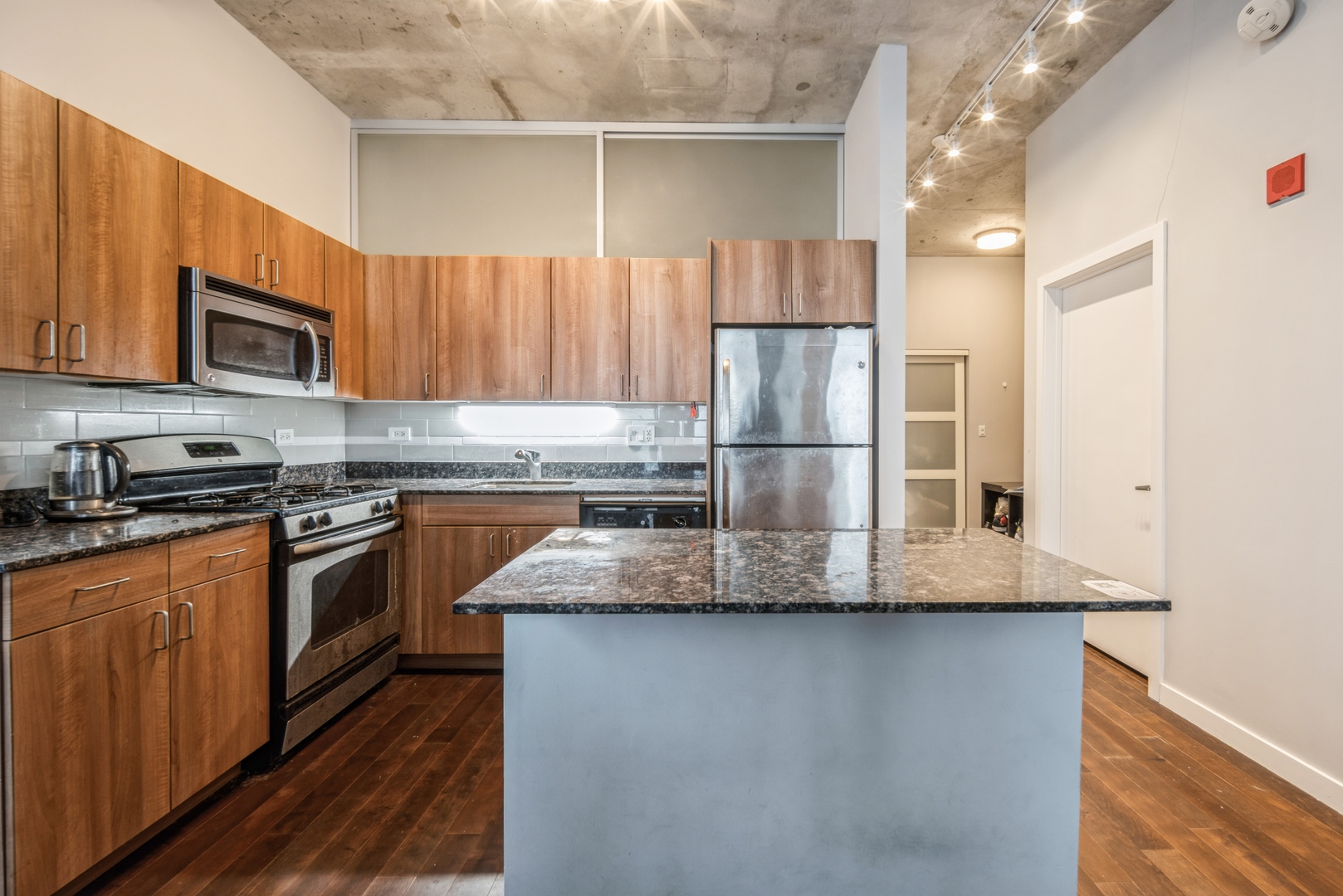 235 West Van Buren Street, Unit 4214 Chicago, IL 60607 - Photo 4 of 16 a kitchen with stainless steel appliances granite countertop a refrigerator a stove a sink and a microwave