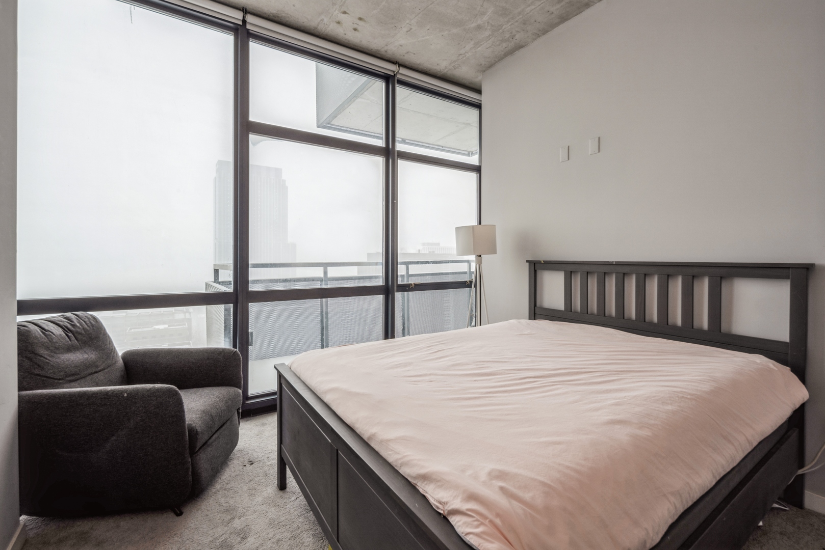 235 West Van Buren Street, Unit 4214 Chicago, IL 60607 - Photo 5 of 16 a bedroom with a bed couch and a large window