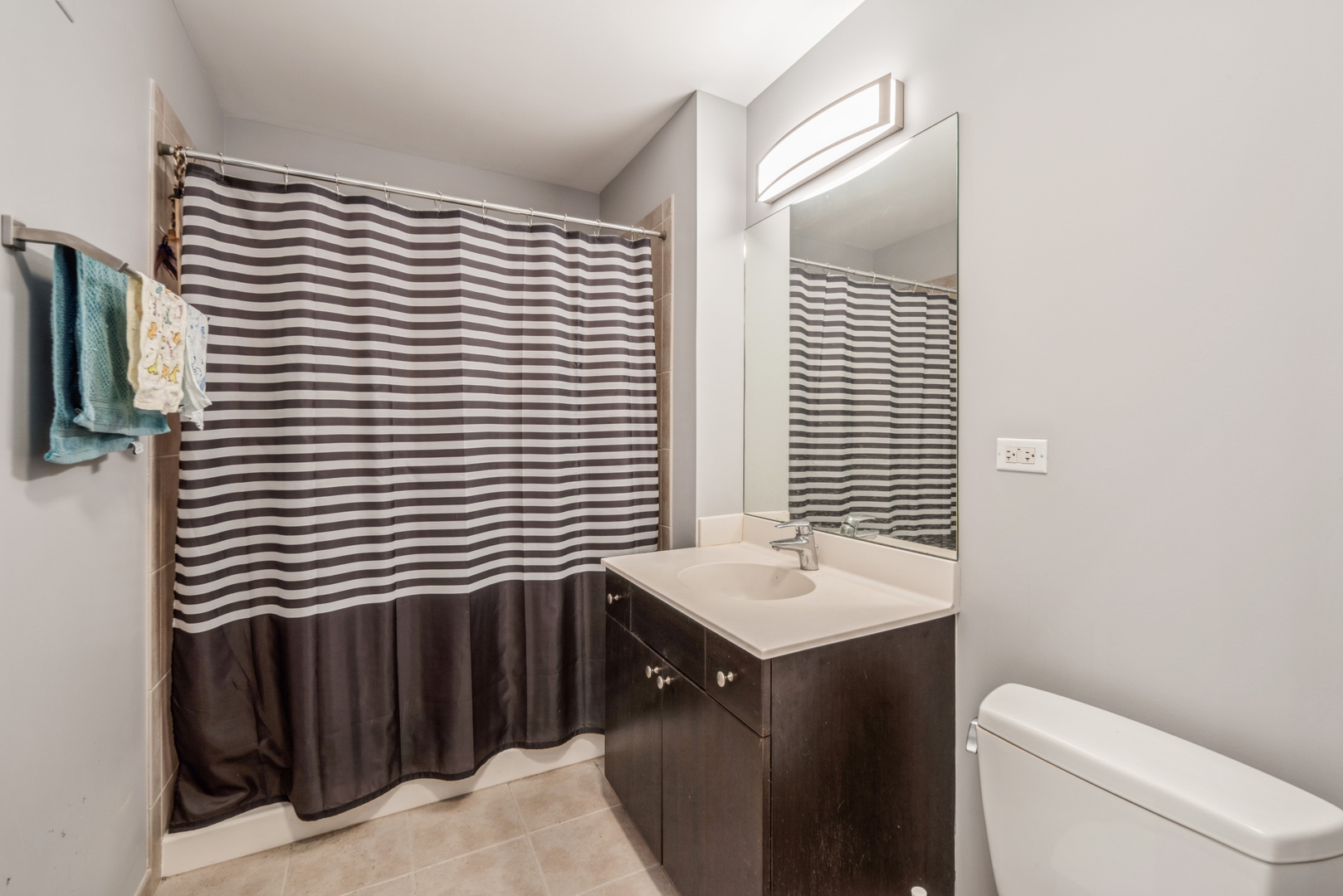 235 West Van Buren Street, Unit 4214 Chicago, IL 60607 - Photo 9 of 16 a bathroom with a sink a toilet and shower curtain