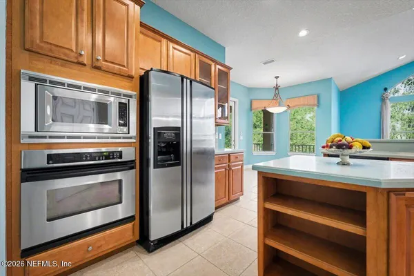 a kitchen with stainless steel appliances granite countertop a refrigerator and a stove