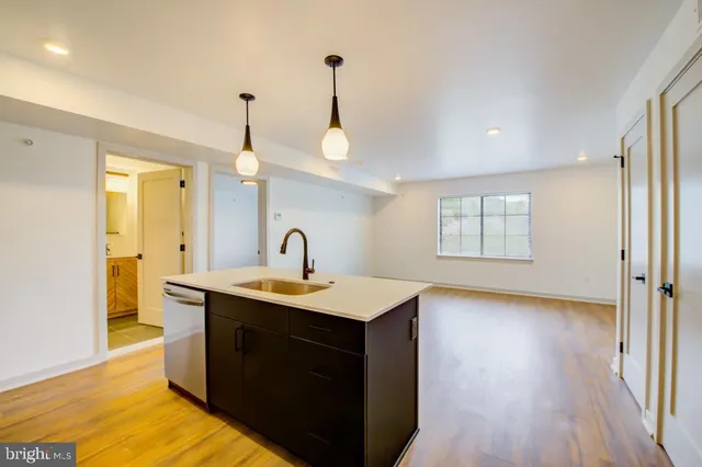 a utility room with a sink a window and wooden floor