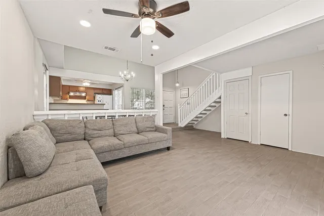 a view of a livingroom with furniture wooden floor and a chandelier