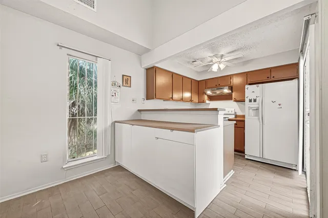 a kitchen with a refrigerator sink and cabinets