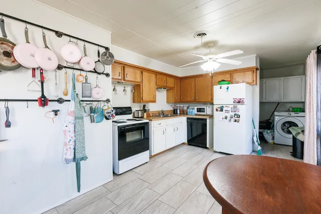 a kitchen with stainless steel appliances granite countertop a refrigerator a sink and white cabinets