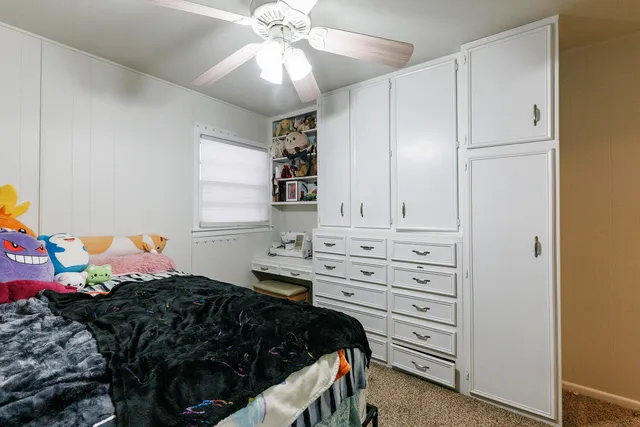 a bedroom with a bed and a ceiling fan