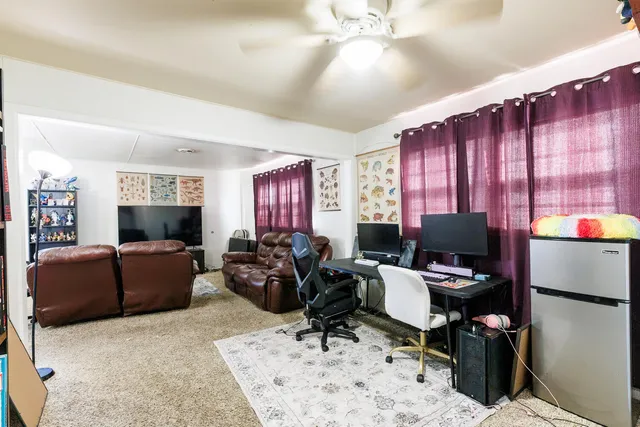 a living room with furniture a flat screen tv and a window