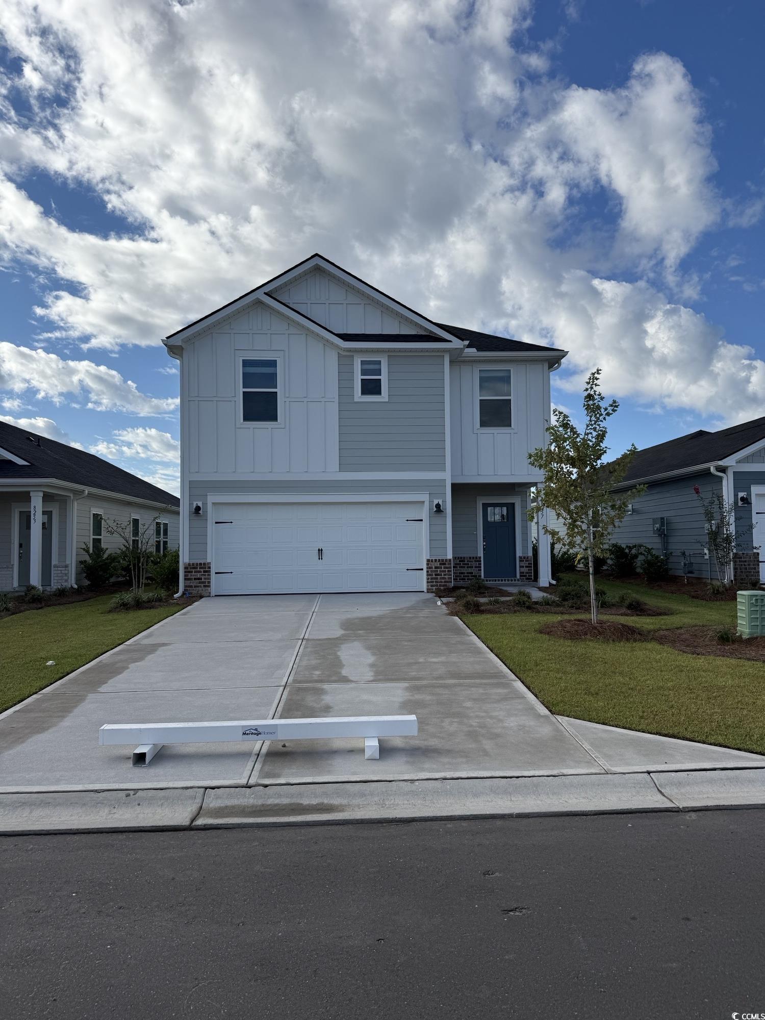 8257 Vibrant Loop Longs, SC 29568 - Photo 1 of 3 View of front of property with board and batten siding, driveway, an attached garage, and a front yard
