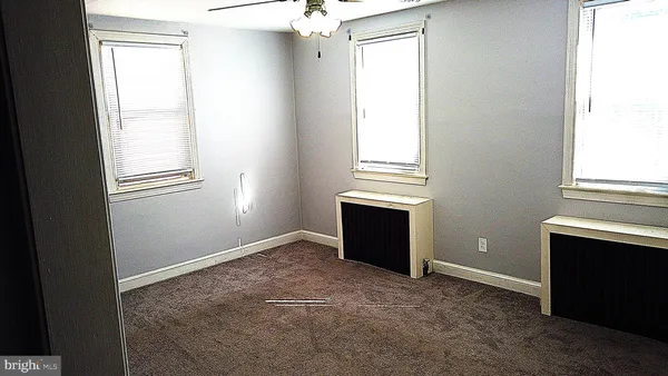 an empty room with windows and closet