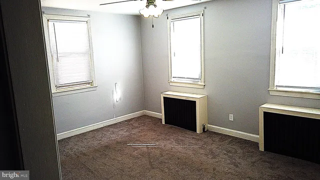 an empty room with windows and closet