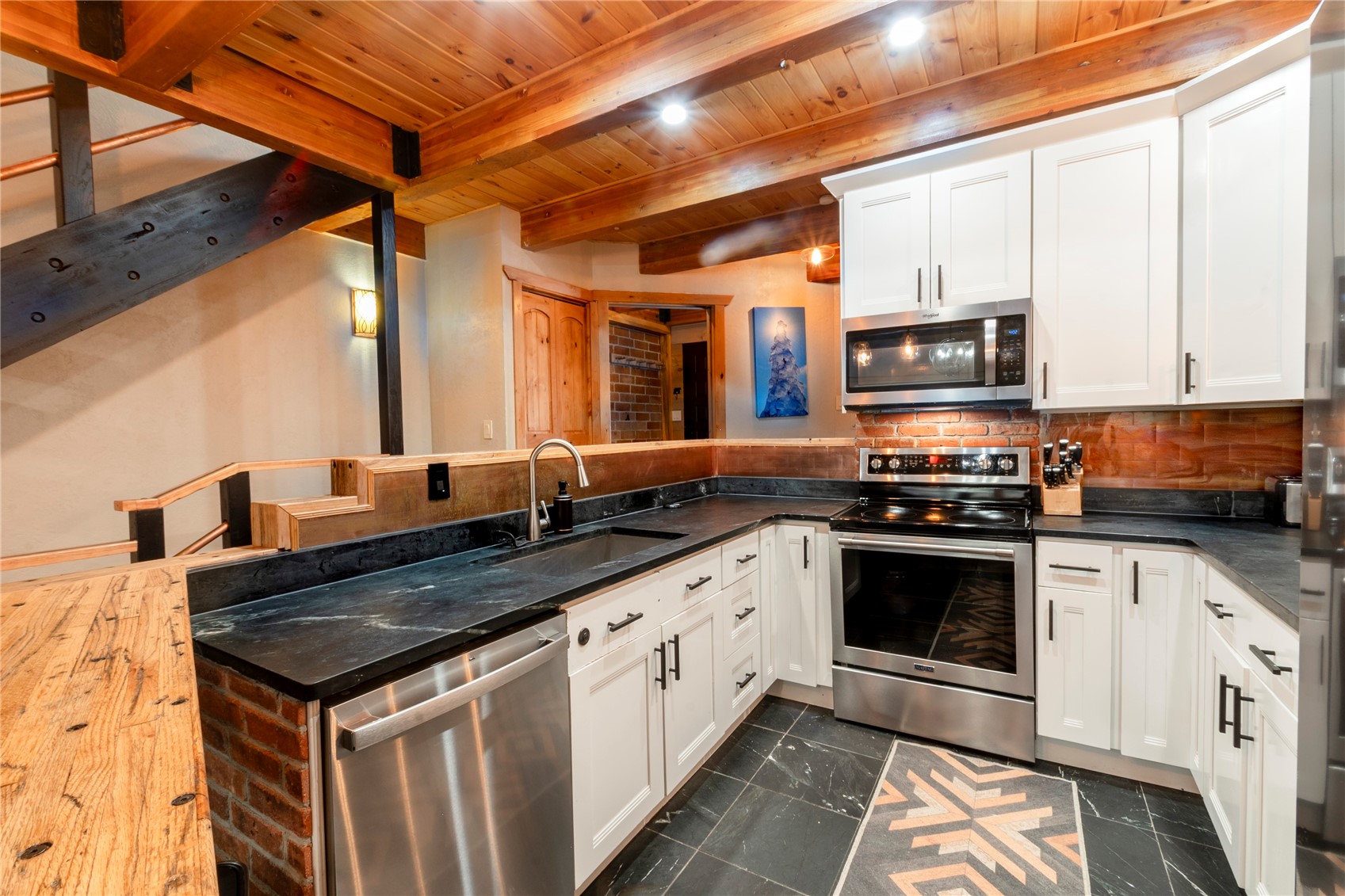 2739 Burgess Creek Road, Unit 10 Steamboat Springs, CO 80487 - Photo 12 of 46 a kitchen with stainless steel appliances granite countertop a stove a sink and a microwave