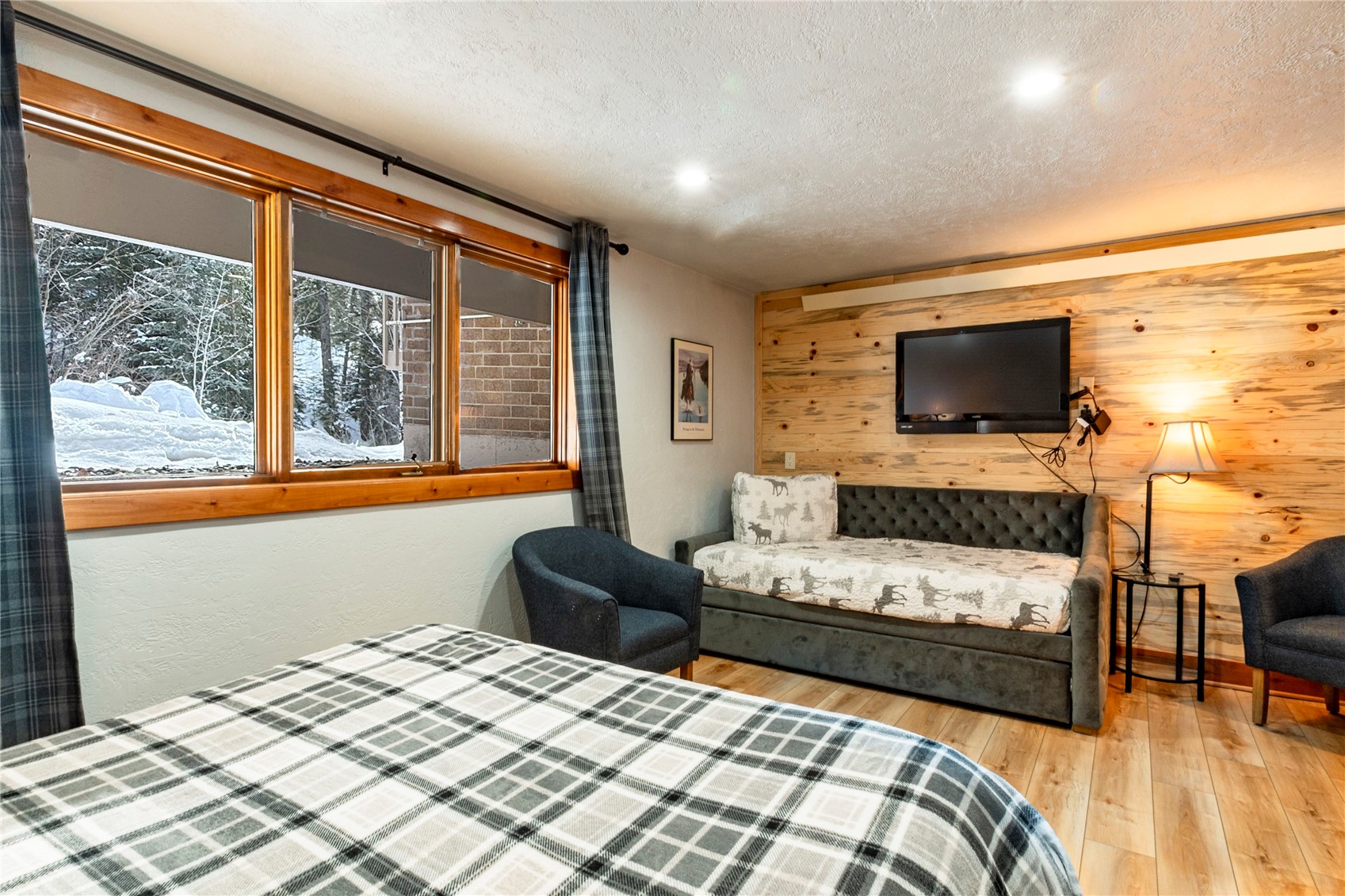 2739 Burgess Creek Road, Unit 10 Steamboat Springs, CO 80487 - Photo 27 of 46 a bedroom with a bed couch and a flat tv screen next to a window