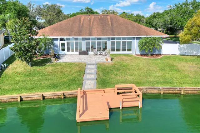 an aerial view of residential houses with outdoor space and trees
