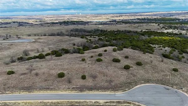 a view of a dry yard with wooden fence