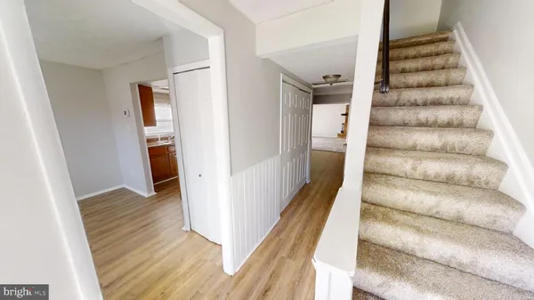 a view of a hallway with wooden floor and entryway