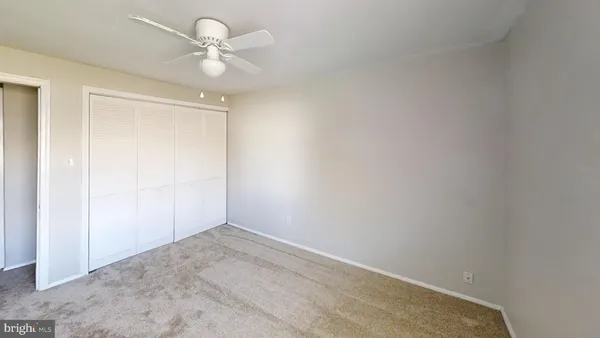 an empty room with a ceiling fan and a window