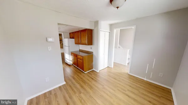 a view of a hallway with wooden floor and a bathroom