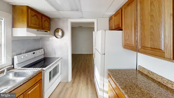 a kitchen with stainless steel appliances granite countertop a refrigerator and a stove top oven