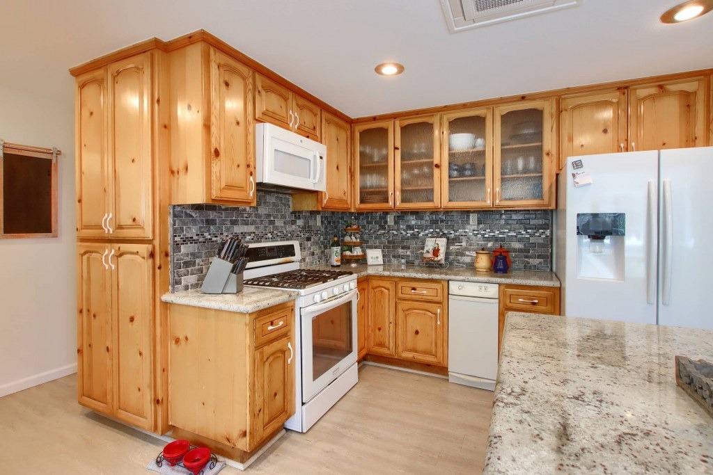50537 Cedar Valley Drive Oakhurst, CA 93644 - Photo 19 of 59 a kitchen with stainless steel appliances granite countertop a stove and a refrigerator