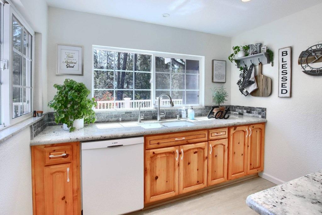 50537 Cedar Valley Drive Oakhurst, CA 93644 - Photo 21 of 59 a kitchen with stainless steel appliances granite countertop a sink and a granite counter tops with white cabinets