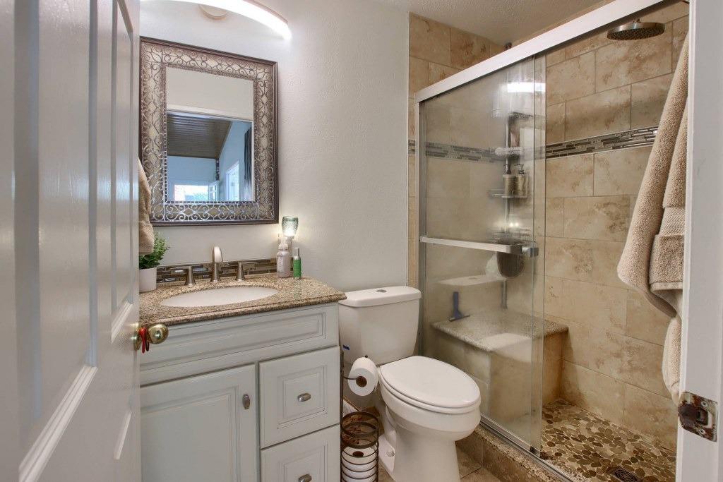 50537 Cedar Valley Drive Oakhurst, CA 93644 - Photo 27 of 59 a bathroom with a granite countertop toilet sink and shower