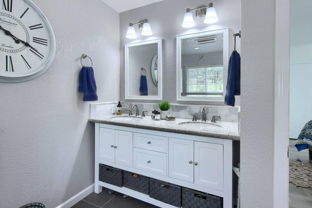 50537 Cedar Valley Drive Oakhurst, CA 93644 - Photo 33 of 59 a bathroom with a double vanity sink and a mirror