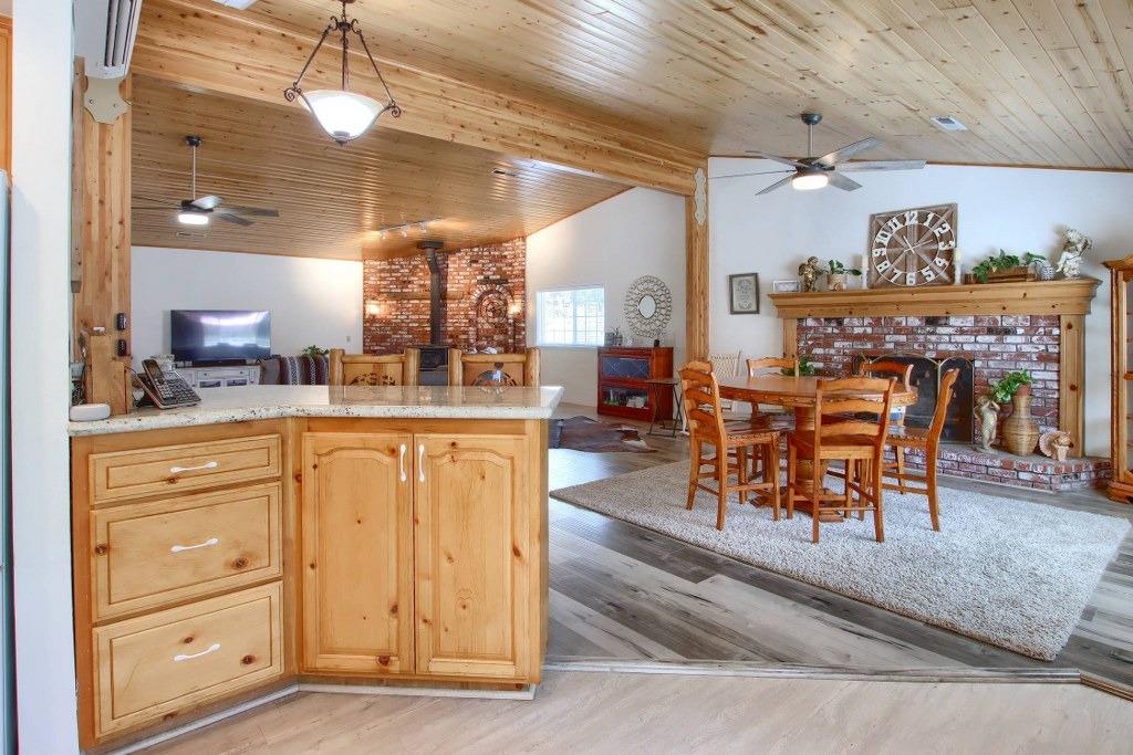 50537 Cedar Valley Drive Oakhurst, CA 93644 - Photo 9 of 59 a dining hall with stainless steel appliances kitchen island granite countertop a table chairs and a view of living room