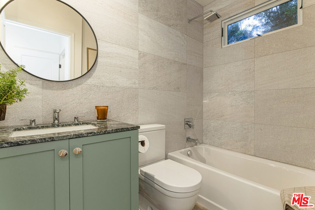 1411 Wellesley Drive Glendale, CA 91205 - Photo 19 of 32 a bathroom with a granite countertop toilet a sink and a mirror