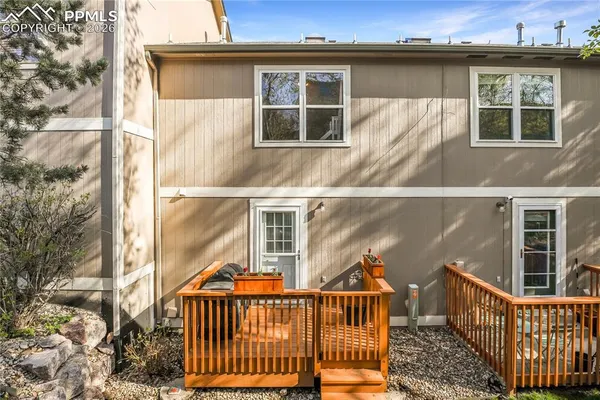 a view of a house with a small yard and wooden fence
