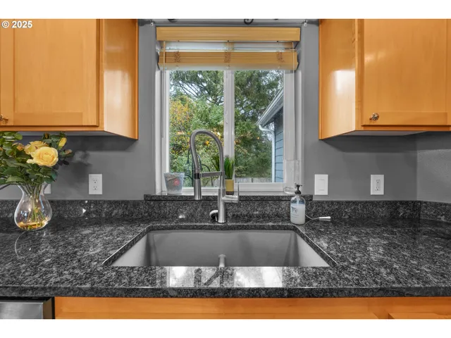 a kitchen with sink a window and cabinets