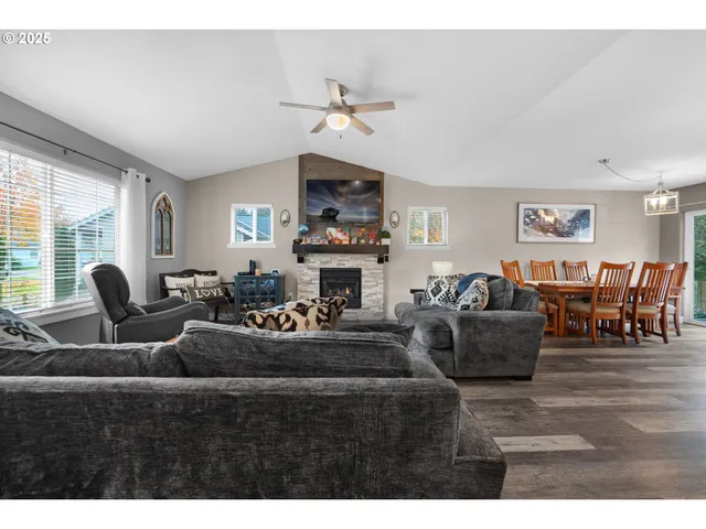 a living room with fireplace furniture and a large window