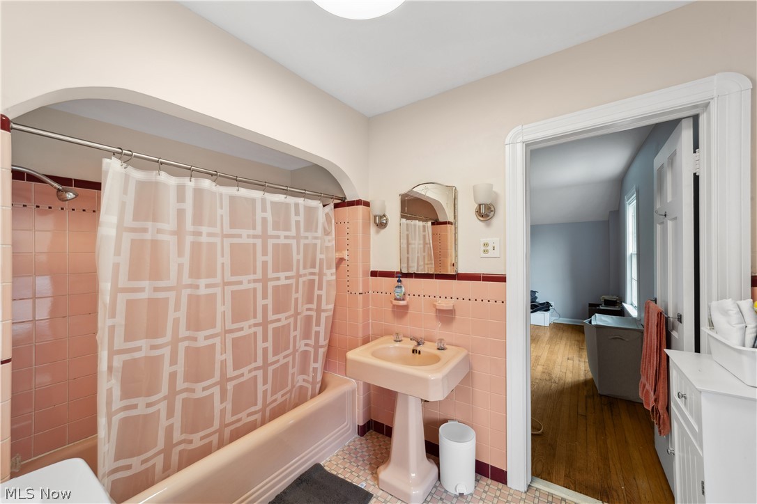 3045 Keswick Road Cleveland, OH 44120 - Photo 35 of 48 Bathroom featuring hardwood / wood-style flooring, shower / bath combo with shower curtain, and tile walls