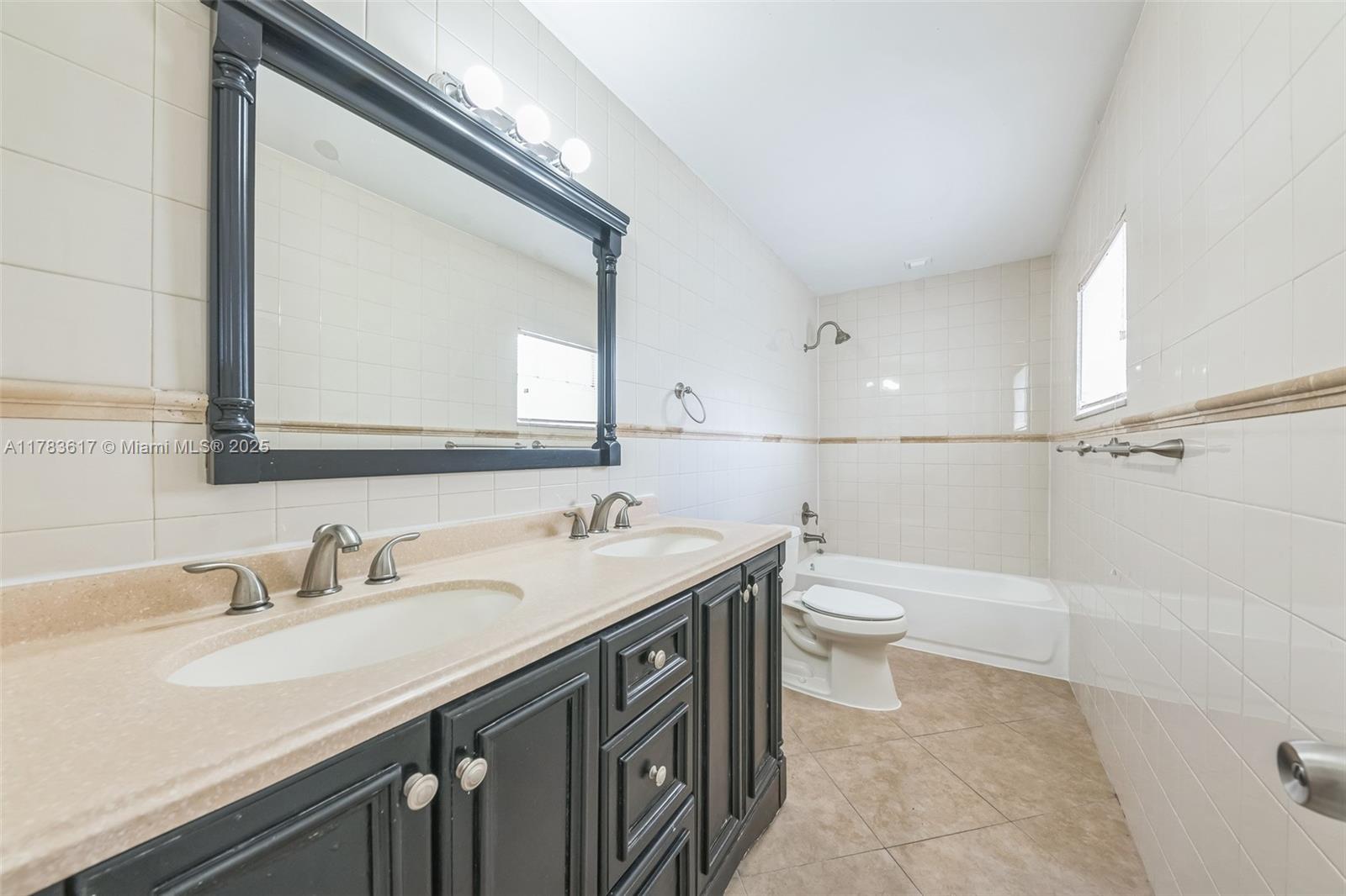 9219 Southwest 1st Place Boca Raton, FL 33428 - Photo 8 of 15 a bathroom with a double vanity sink and a mirror