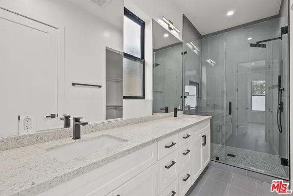 a bathroom with a sink double vanity and a shower
