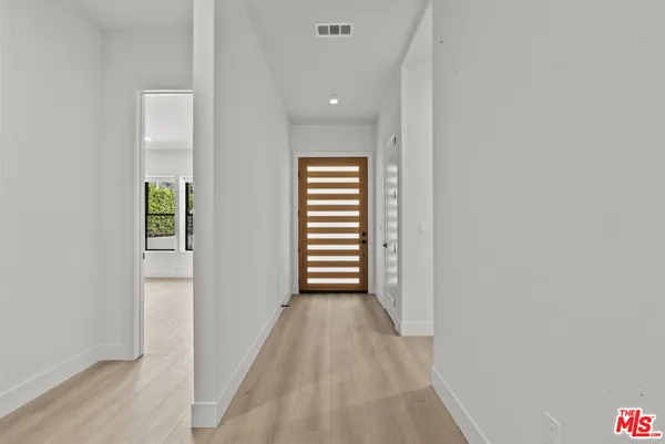 a view of hallway with stairs and wooden floor