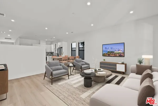 a living room with furniture a rug and white walls