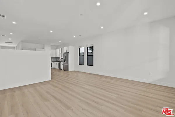 a view of an empty room with wooden floor