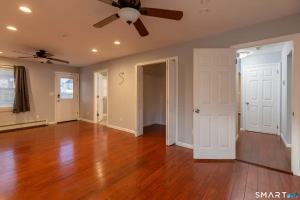 an empty room with wooden floor and windows