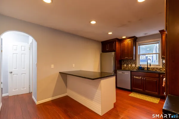 a kitchen with stainless steel appliances granite countertop a refrigerator and a stove top oven
