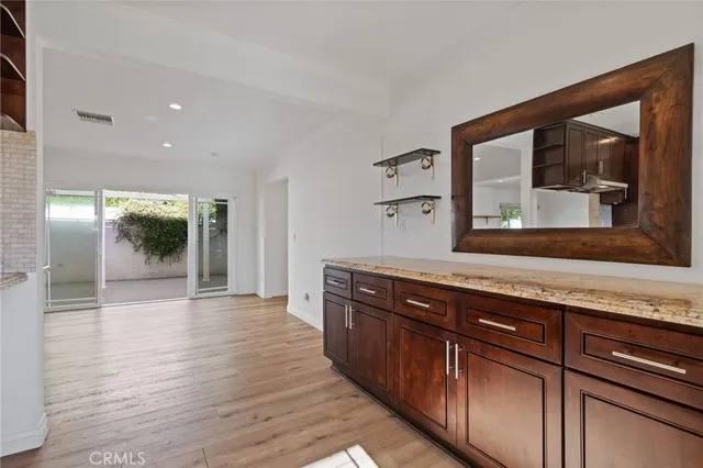 a kitchen with stainless steel appliances granite countertop wooden cabinets a stove and a sink