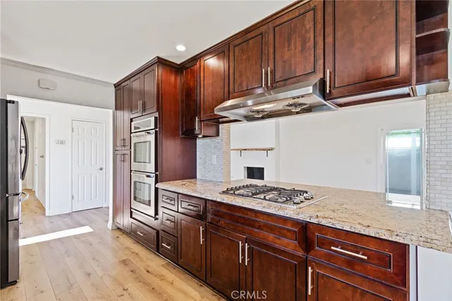 a kitchen with granite countertop stainless steel appliances stove microwave and cabinets